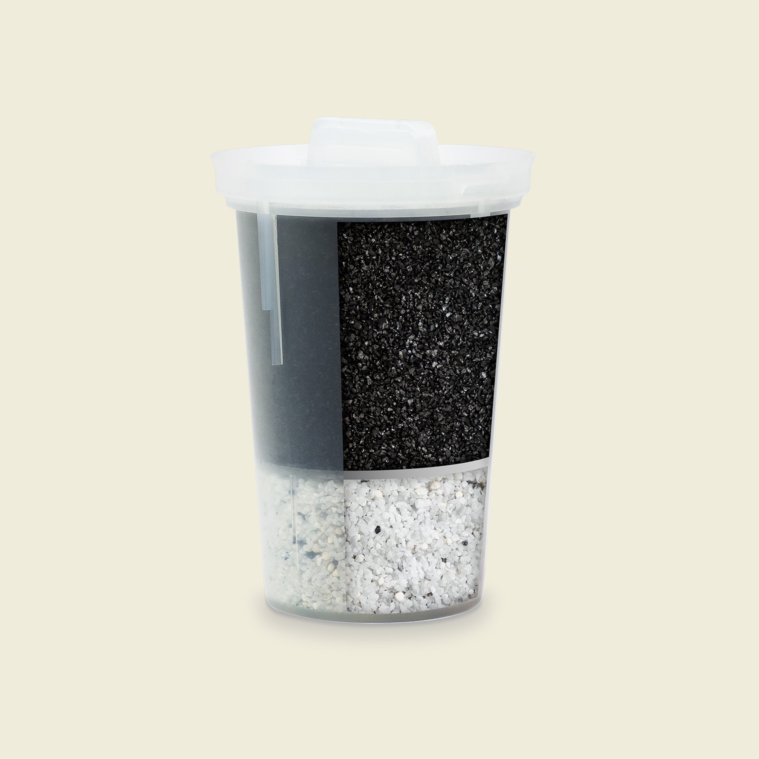 Container with black top and white bottom filled with small stones on a beige background