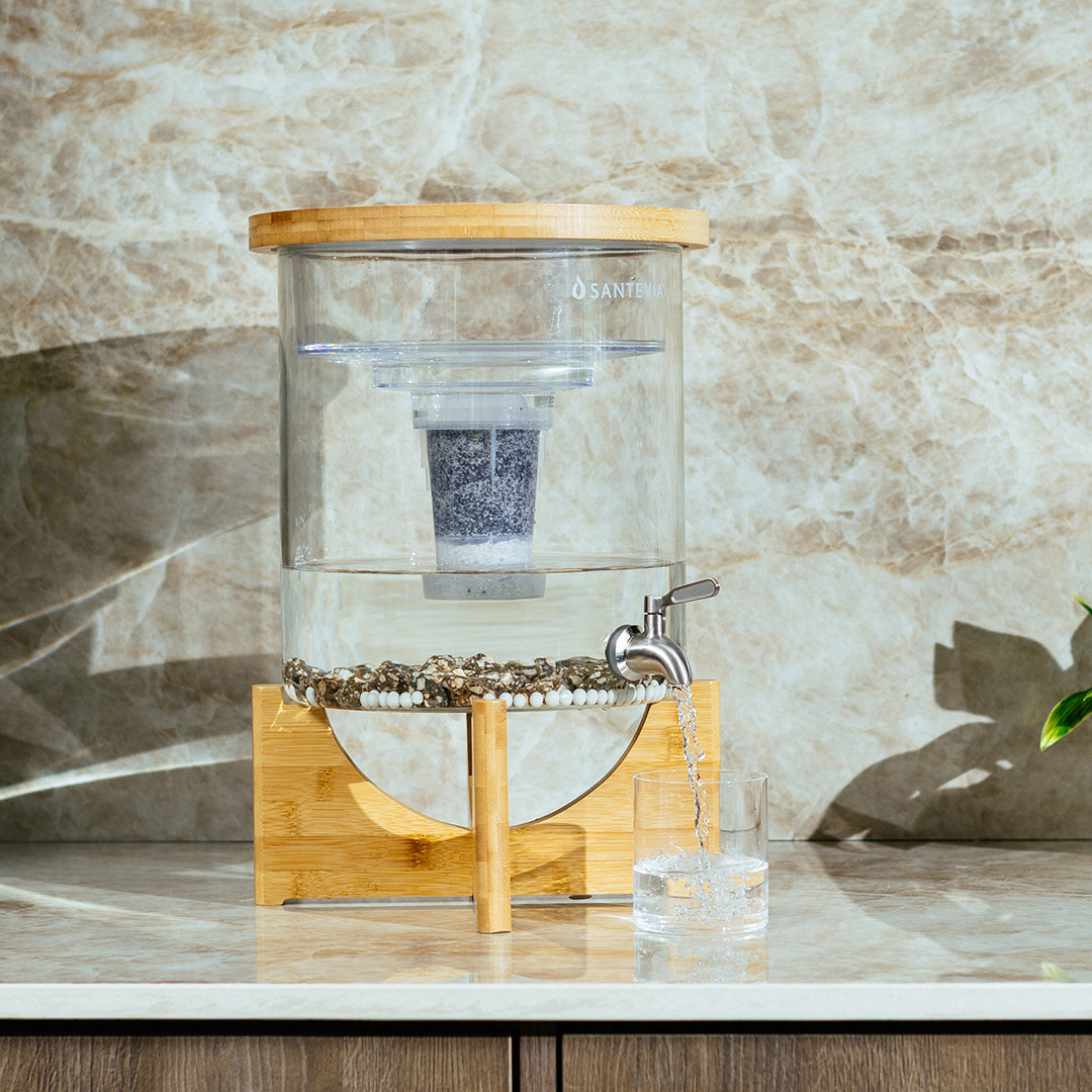 Santevia Glass Water System filling a glass of water in a bright beige kitchen