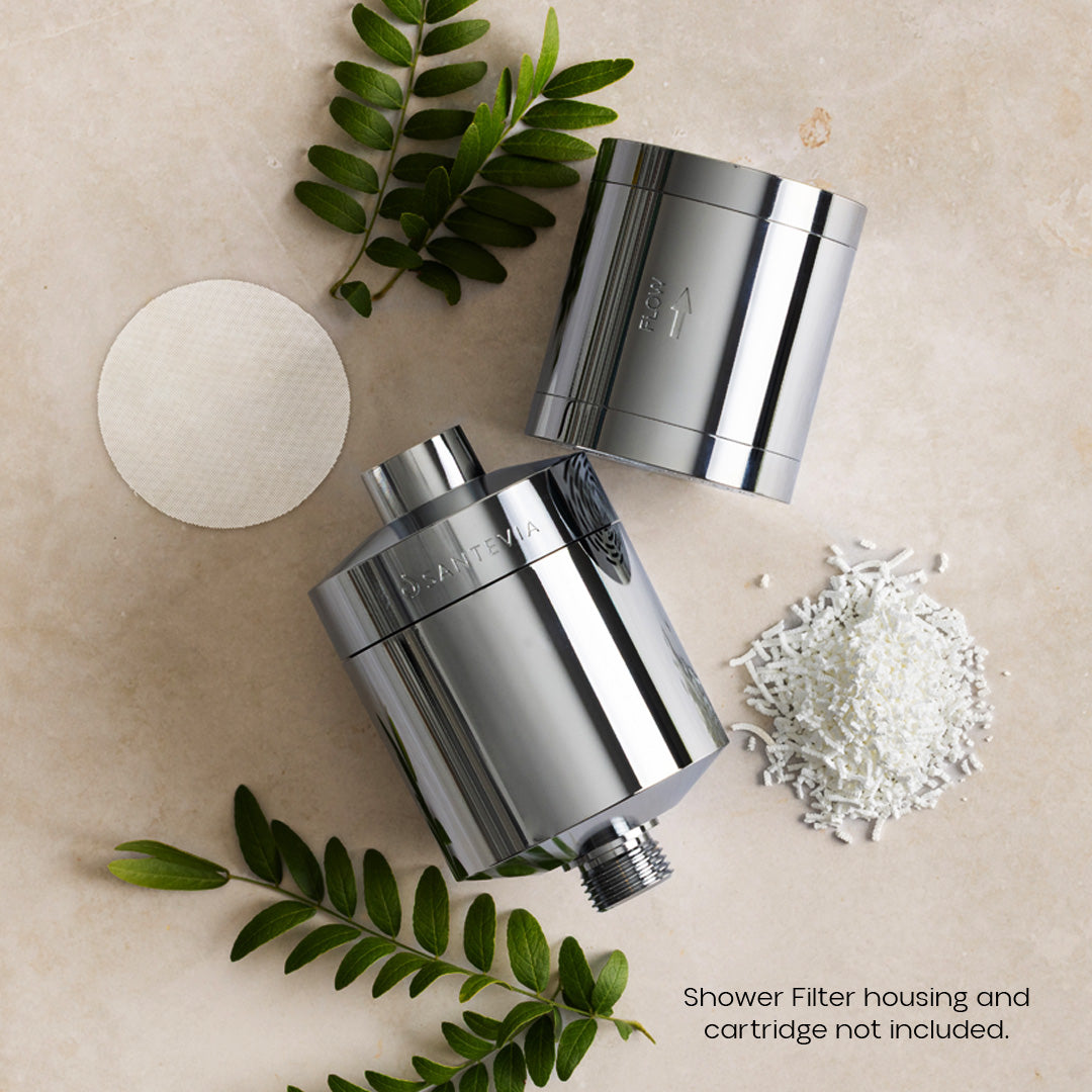 Chrome shower filter housings with decorative elements on a beige surface