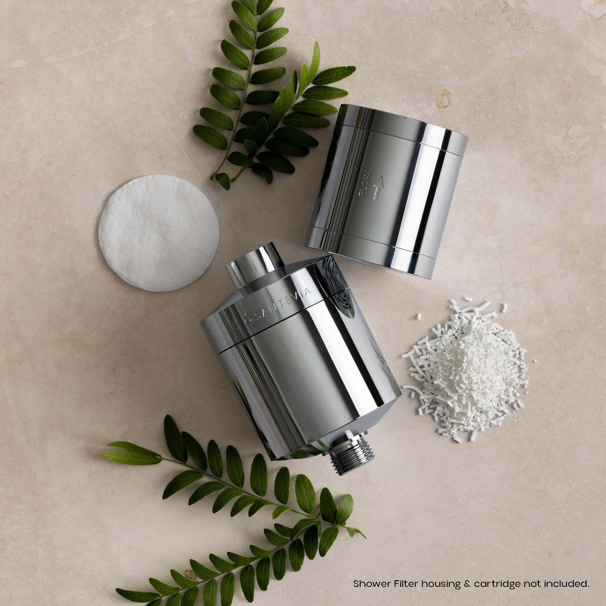 Chrome shower filter housings with decorative elements on a beige surface