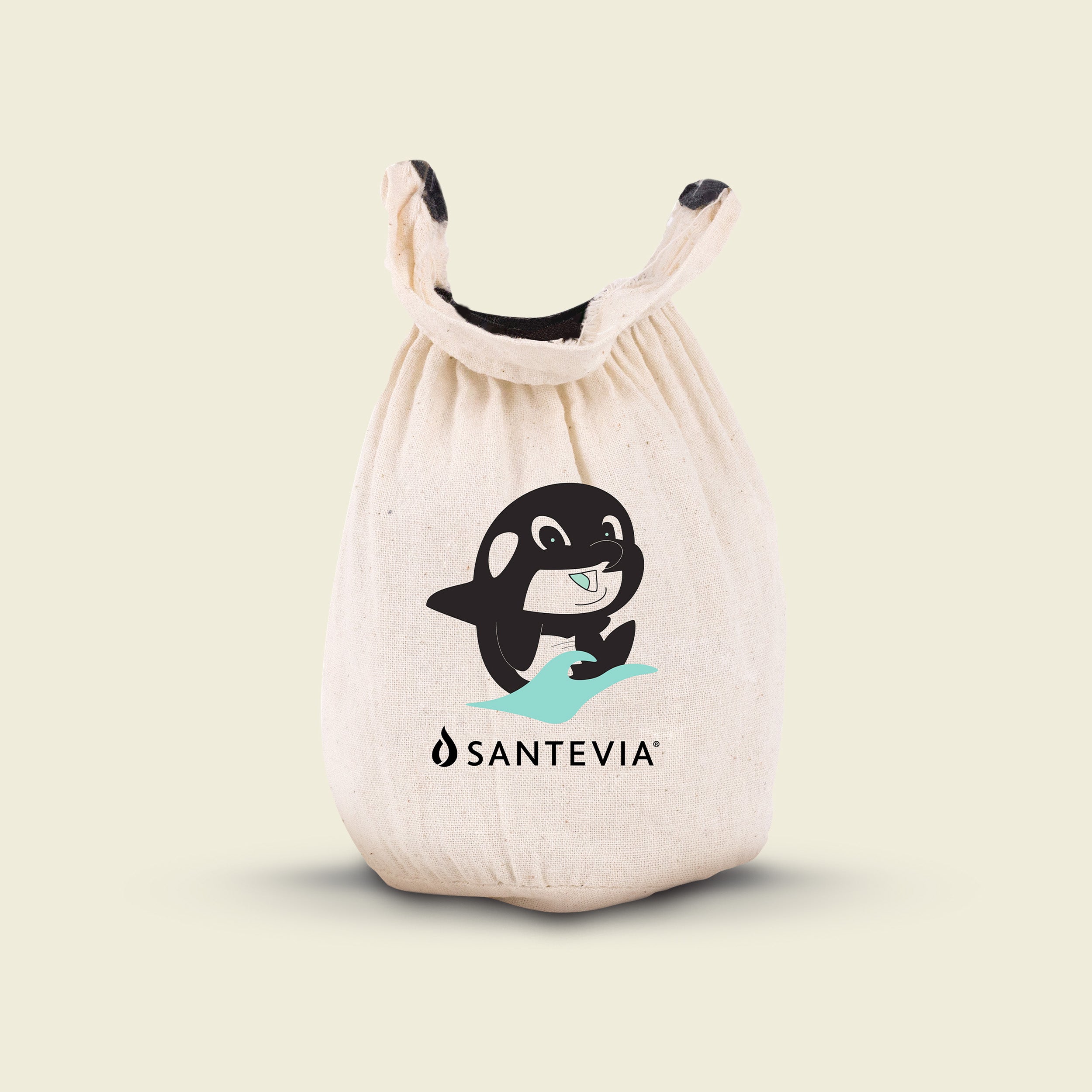 White drawstring bag with a cartoon orca and Santevia logo on a beige background