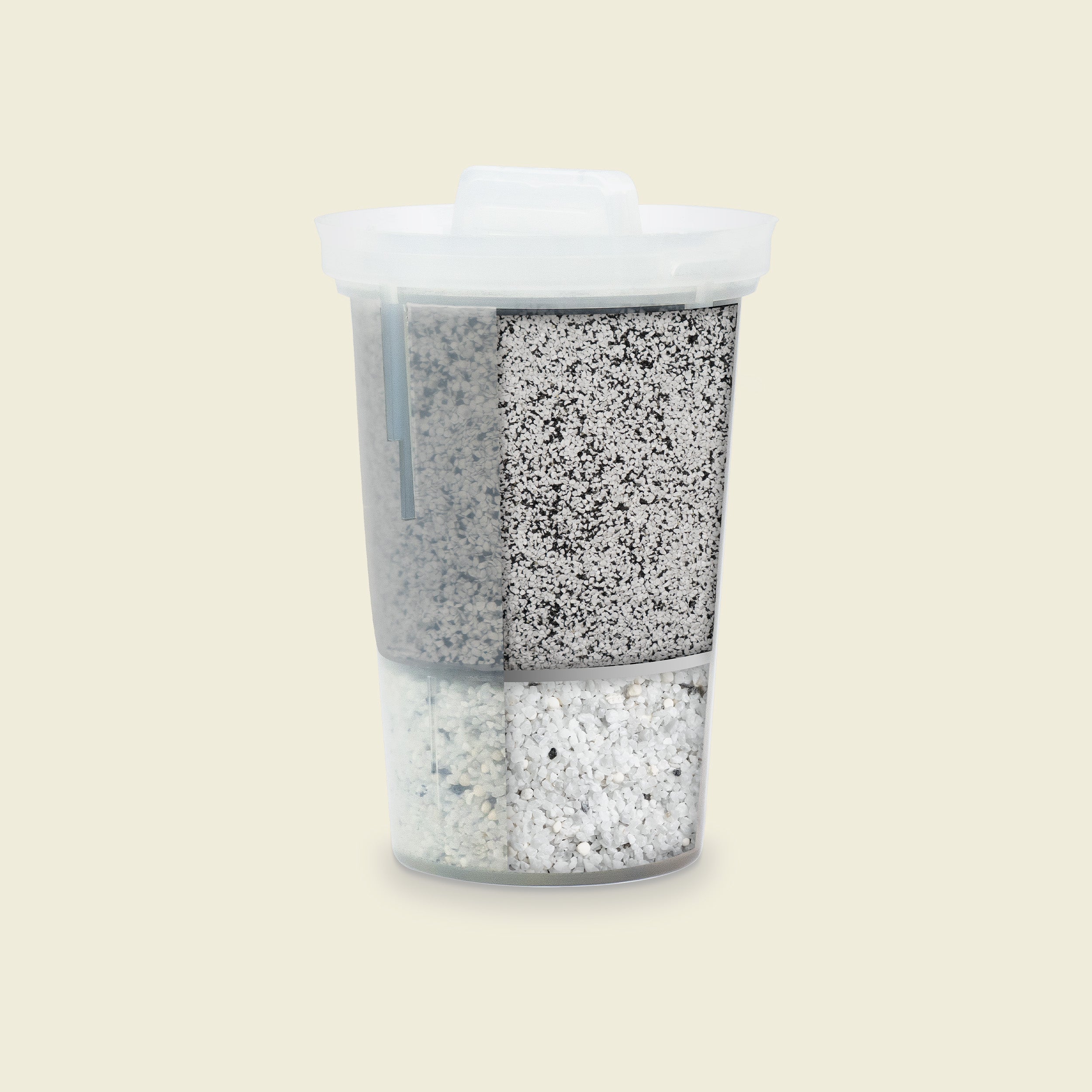 Container with layered gray and white granular material on a beige background