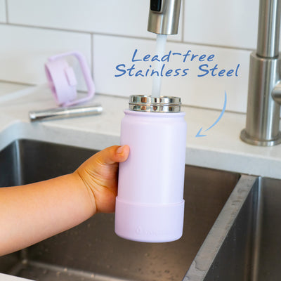 Santevia Kids Bottle Lavender being filled at sink by child with Santevia Water Bottle Filter in the background. Lead-free Stainless Steel