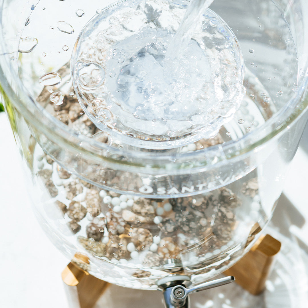 Top down view of a Santevia Glass Water System being filled with water to be filtered