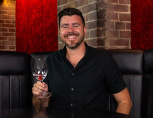 A sommelier holding a wine glass of Santevia Alkaline Mineral Water 