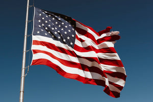 Flag of the United States of America flowing in the wind, against a blue background