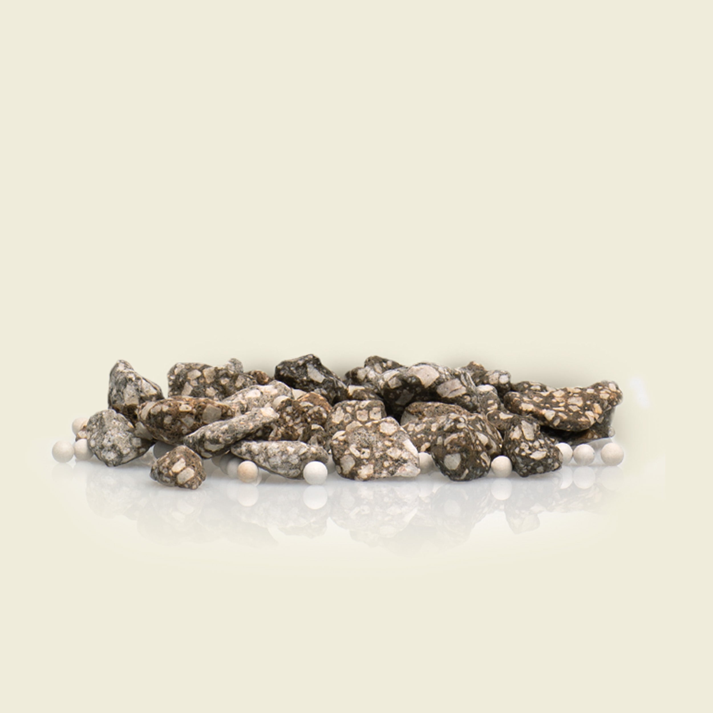 Decorative arrangement of rocks and pearls on a light beige background