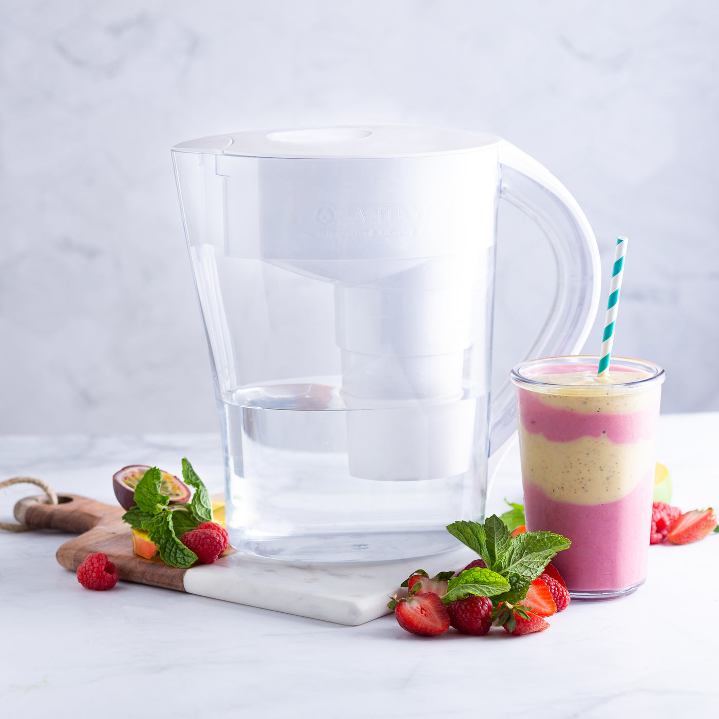 The Santevia MINA Alkaline Pitcher with a strawberry, passion fruit, and strawberry alkaline smoothie#color_white
